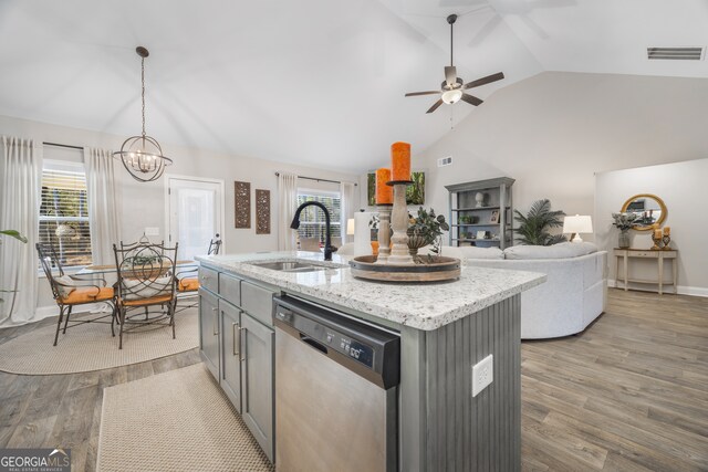 kitchen featuring decorative light fixtures, a center island with sink, stainless steel appliances, white cabinetry, and light wood-type flooring