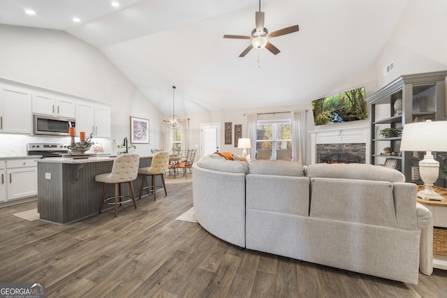 living room with visible vents, a ceiling fan, dark wood-style flooring, a fireplace, and high vaulted ceiling