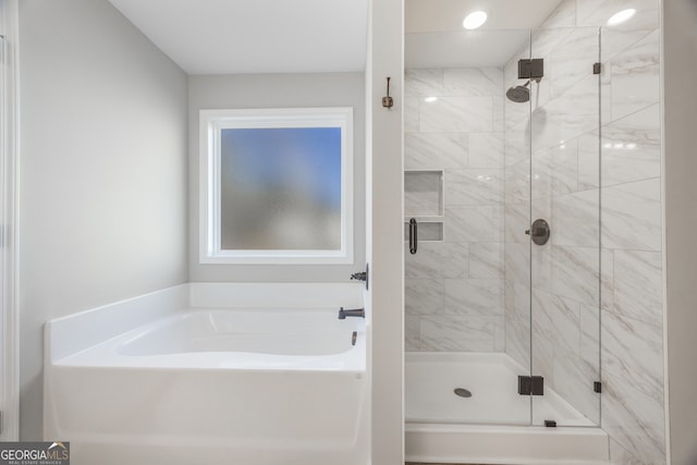 bathroom featuring a shower stall and a bath