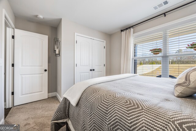 bedroom featuring baseboards, visible vents, a closet, and light colored carpet