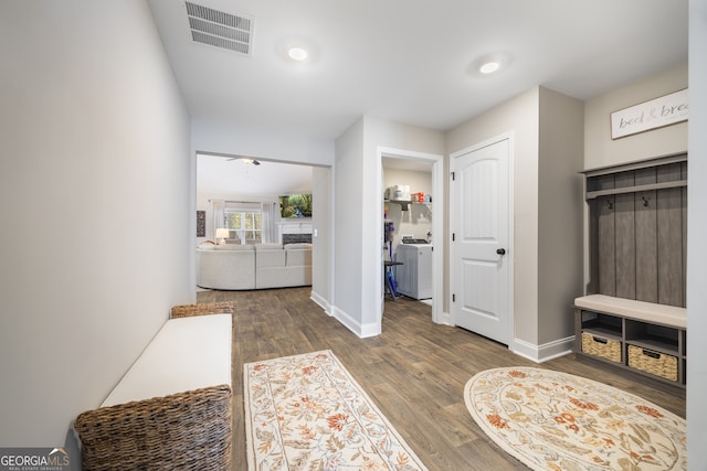 interior space with baseboards, visible vents, ceiling fan, and wood finished floors