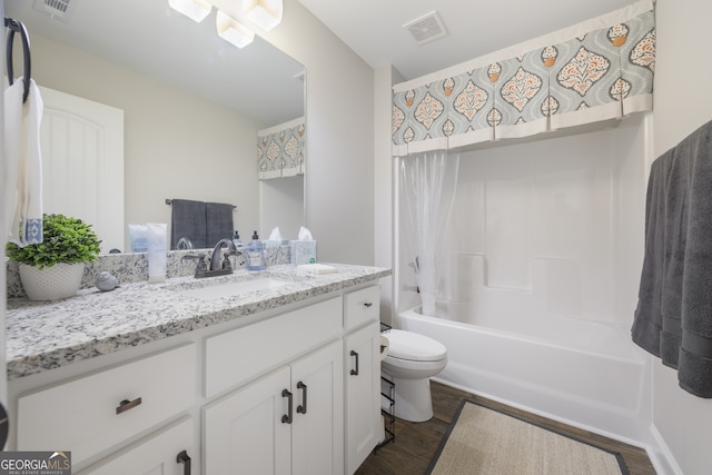 full bathroom with shower / washtub combination, visible vents, toilet, vanity, and wood finished floors