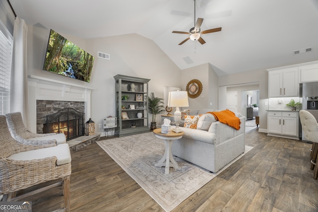 living area featuring dark wood-style floors, visible vents, and a fireplace