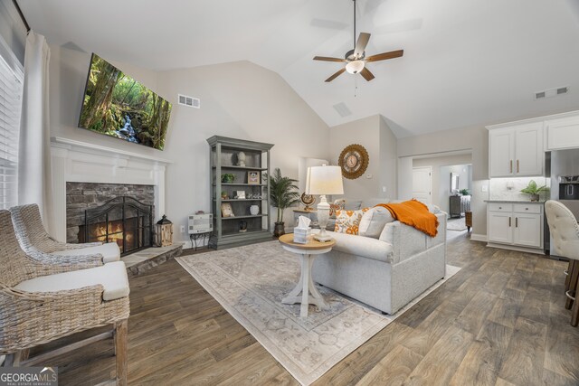 living room featuring high vaulted ceiling, light wood-type flooring, visible vents, and a ceiling fan