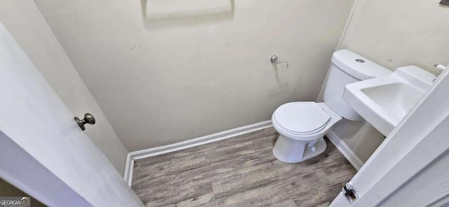 bathroom with hardwood / wood-style flooring, sink, and toilet