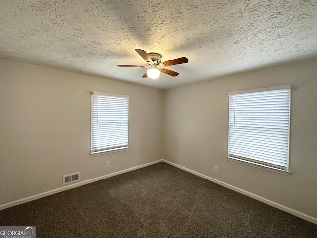 carpeted empty room featuring ceiling fan and a textured ceiling