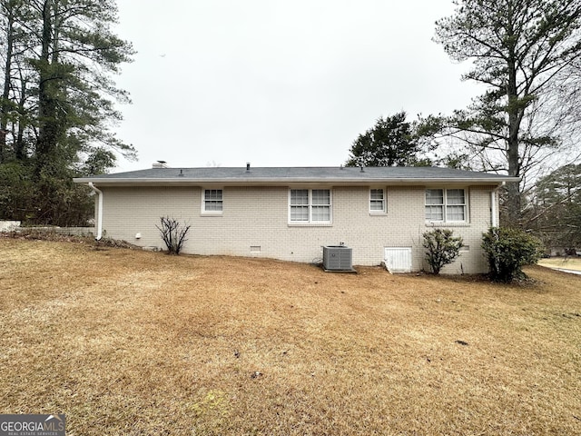 back of property with a yard and central air condition unit