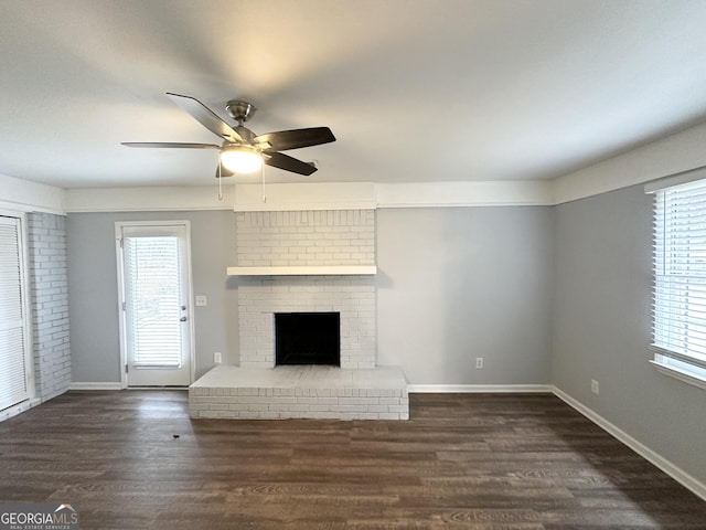 unfurnished living room featuring ceiling fan, a fireplace, and dark hardwood / wood-style flooring