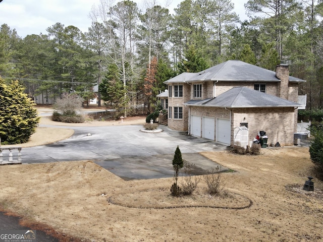 view of property exterior with a garage and central AC