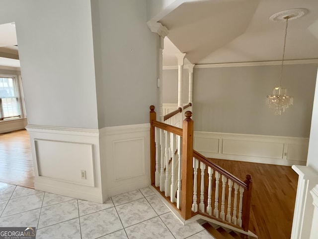 stairs with tile patterned floors and a chandelier