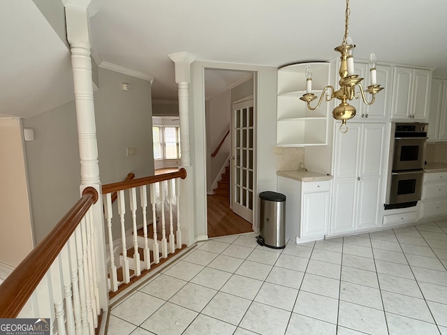 interior space featuring ornamental molding, light tile patterned floors, and an inviting chandelier