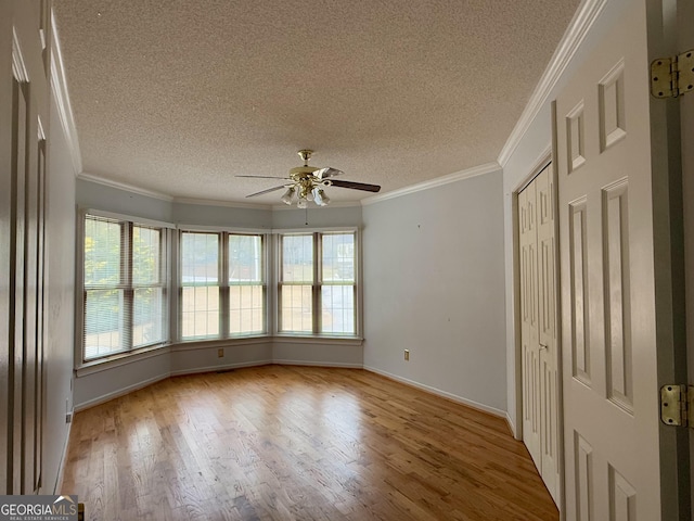 unfurnished room with plenty of natural light, ornamental molding, and light wood-type flooring