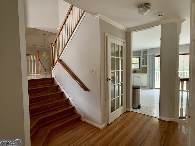 stairs featuring hardwood / wood-style flooring and ornamental molding