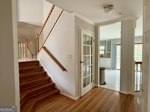 staircase with hardwood / wood-style floors and crown molding