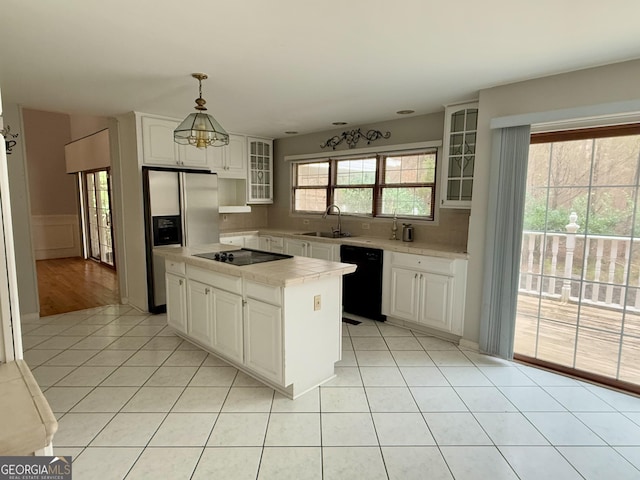 kitchen with sink, white cabinetry, hanging light fixtures, a kitchen island, and black appliances