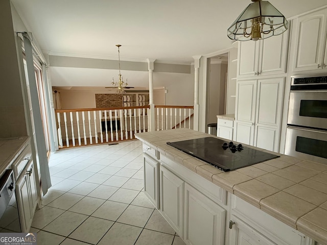 kitchen with pendant lighting, tile countertops, black electric cooktop, and stainless steel double oven