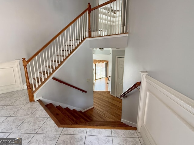 stairs featuring tile patterned flooring and a high ceiling