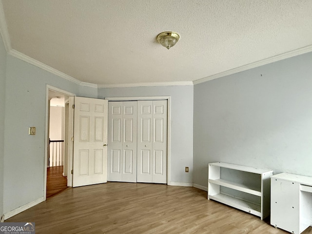 unfurnished bedroom featuring ornamental molding, hardwood / wood-style floors, and a textured ceiling