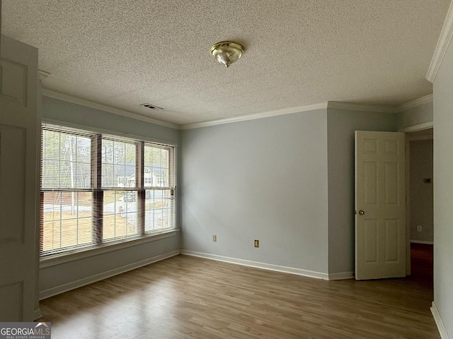 unfurnished room with crown molding, hardwood / wood-style flooring, and a textured ceiling