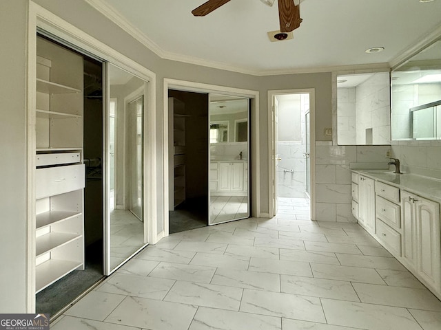 bathroom with crown molding, tile walls, vanity, and ceiling fan