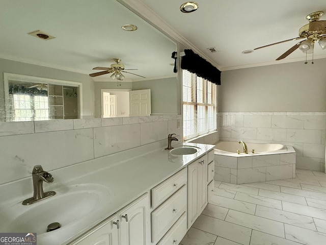 bathroom with tiled tub, ornamental molding, a healthy amount of sunlight, and vanity