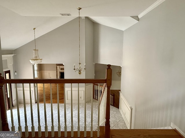 stairs with lofted ceiling and a notable chandelier