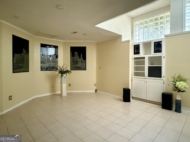 unfurnished room with light tile patterned floors and ornamental molding