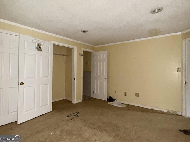 unfurnished bedroom with crown molding, carpet flooring, and a closet