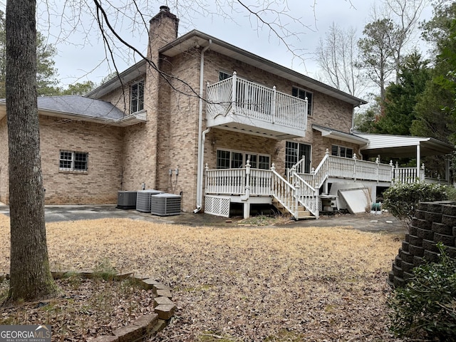 back of house with a wooden deck and a balcony