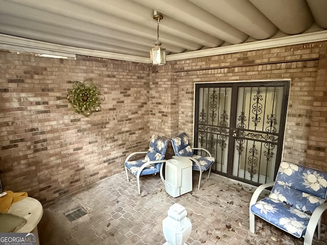 interior space with beam ceiling and brick wall