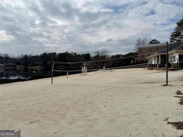 view of home's community with a water view and volleyball court