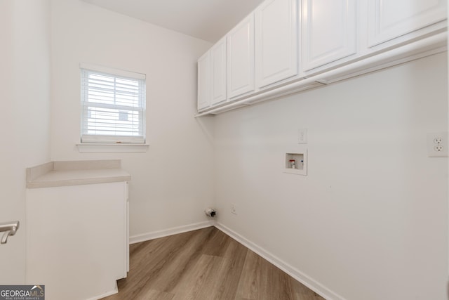 washroom featuring cabinets, washer hookup, and light hardwood / wood-style flooring