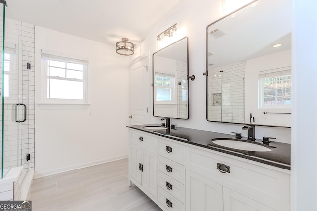 bathroom featuring plenty of natural light, an enclosed shower, and vanity