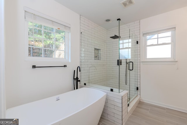 bathroom featuring shower with separate bathtub