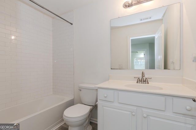 full bathroom featuring vanity, tiled shower / bath, and toilet