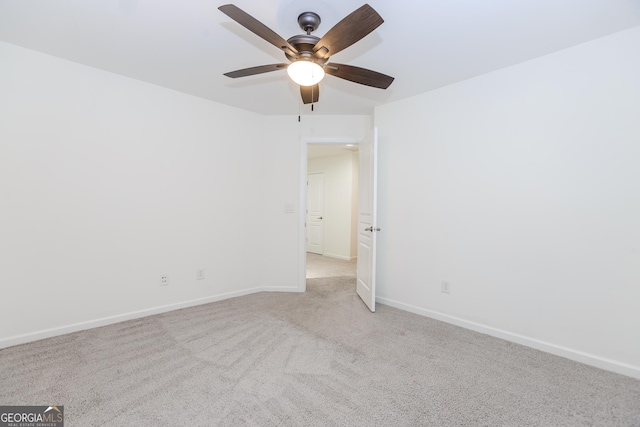 carpeted spare room featuring ceiling fan