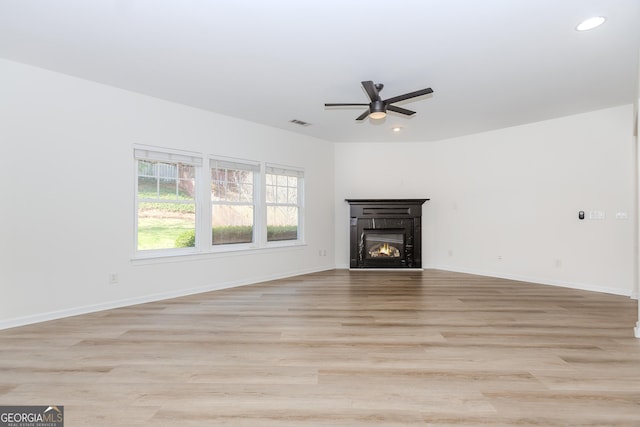 unfurnished living room featuring ceiling fan and light wood-type flooring