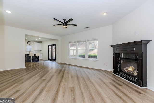 unfurnished living room featuring ceiling fan and light wood-type flooring