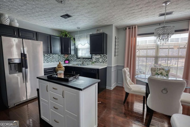 kitchen featuring pendant lighting, sink, dark hardwood / wood-style floors, and stainless steel refrigerator with ice dispenser