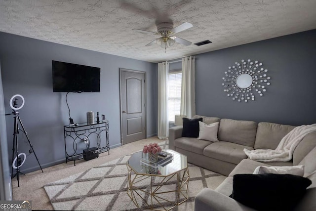 carpeted living room with a textured ceiling and ceiling fan