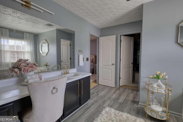 bathroom with vanity, hardwood / wood-style floors, and a textured ceiling