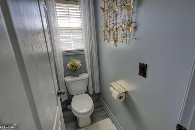 bathroom with hardwood / wood-style flooring and toilet