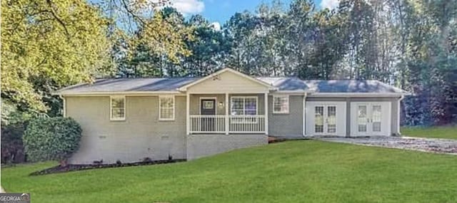 rear view of property with a porch, a yard, and french doors