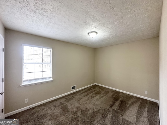 unfurnished room with carpet floors and a textured ceiling