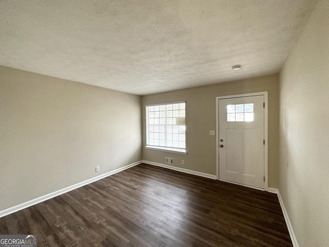 entrance foyer featuring dark hardwood / wood-style floors and a textured ceiling
