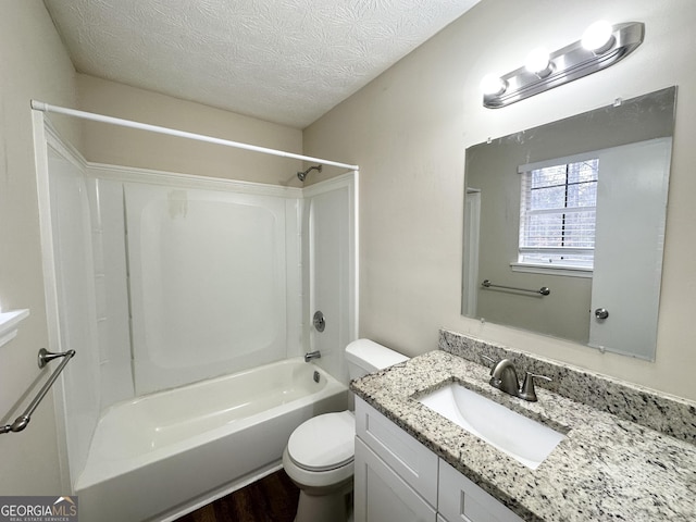 full bathroom featuring shower / bathing tub combination, wood-type flooring, vanity, toilet, and a textured ceiling