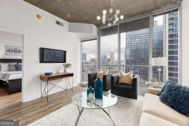 living room featuring hardwood / wood-style flooring, expansive windows, a healthy amount of sunlight, and a chandelier