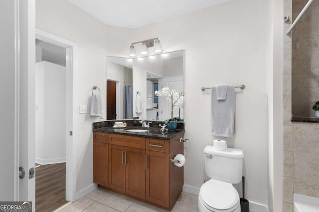 bathroom with vanity, tile patterned flooring, curtained shower, and toilet