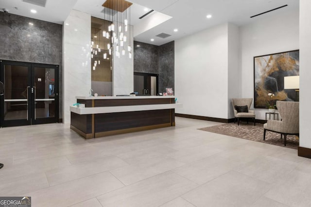 welcome area with an inviting chandelier and french doors