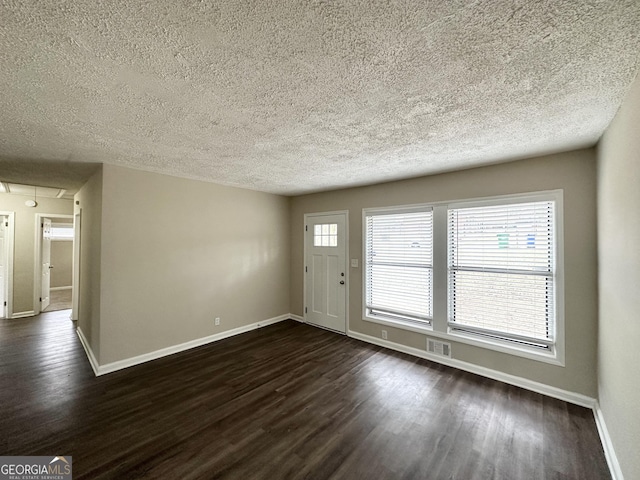 interior space featuring dark wood-type flooring and a textured ceiling